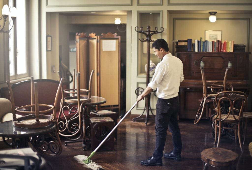 Man sweeping a floor in an office